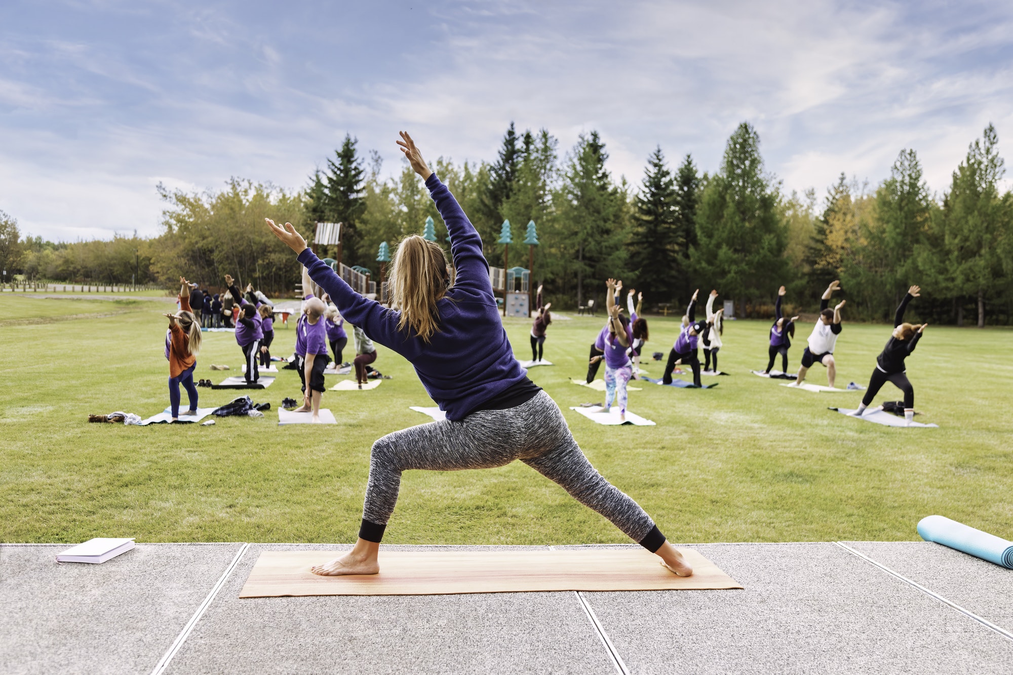 Outdoor Yoga classes. Group of adults attending yoga classes in the park.